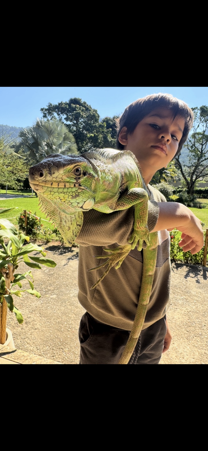 Menino com uma iguana no Sítio Encanto da Ilha